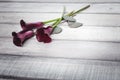 Three violet callas lie on a wooden table, space for text Royalty Free Stock Photo
