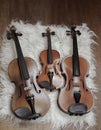 Three violins put on background,show detail and different size Royalty Free Stock Photo