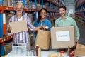 Three volunteers packing eatables in cardboard box