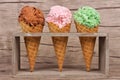 Three waffle cones of ice cream in rustic holder over wood Royalty Free Stock Photo