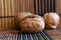 Three walnuts lie on a wooden bamboo table, background for web site or mobile devices. Royalty Free Stock Photo