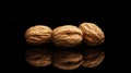 Three walnuts rest reflective surface illuminated soft contour lighting dark background highlighting their textured Royalty Free Stock Photo