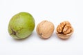 Three walnuts on white background. Green unpeeled walnut, dried and cracked with kernel.
