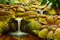 Three waterfalls in a small pond in a garden Royalty Free Stock Photo