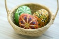 Three wax painted Easter eggs in light brown wicker basket Royalty Free Stock Photo