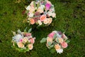 Three wedding bouquets on the green grass.