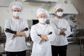 Three well-dressed chefs standing together in the professional kitchen Royalty Free Stock Photo