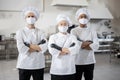 Three well-dressed chefs standing together in the professional kitchen Royalty Free Stock Photo