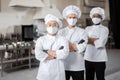 Three well-dressed chefs standing together in the professional kitchen Royalty Free Stock Photo