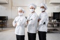 Three well-dressed chefs standing together in the professional kitchen Royalty Free Stock Photo