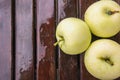 Three wet apples on wooden surface Royalty Free Stock Photo