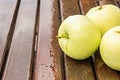 Wet apples on wooden table surface Royalty Free Stock Photo