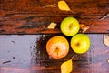 Three wet golden green apples covered by water drops on top of brown wet natural old wooden table surface. Top view and Royalty Free Stock Photo