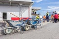 Three wheelbarrows with tools for cleaning are lined up