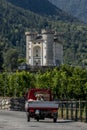 A three-wheeled vehicle travels along a country road near Aymavilles Castle, Aosta Valley, Italy Royalty Free Stock Photo