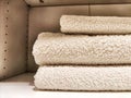 Three white bath towels are neatly folded and stacked in a cabinet Royalty Free Stock Photo