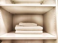 Three white bath towels are neatly folded and stacked in a cabinet Royalty Free Stock Photo