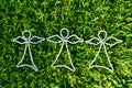 3 white bead angels on freshly mowed green grass background taken from above Royalty Free Stock Photo