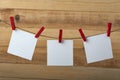 Three white blank note cards hanging with clothespins. Wooden background. Copy space Royalty Free Stock Photo