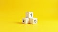 Numbered Blocks Representing a Podium on a Vibrant Yellow Background Royalty Free Stock Photo