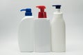 Three white bottles with red and blue pump
