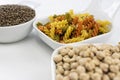 Three white bowls with legumes such as lentils and chickpeas and pasta with colorful vegetables Royalty Free Stock Photo