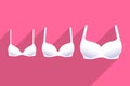 Three white brassieres with cups of different sizes Royalty Free Stock Photo