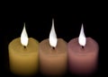 Three white candles green and purple on a black background