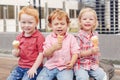 Three white Caucasian cute adorable funny children toddlers sitting together sharing ice-cream Royalty Free Stock Photo