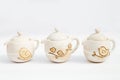 three white ceramic teapots stoneware with white background