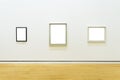 Three white clipped paintings hung on a clear wall.