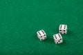 Three White Dice on Green Velvet Casino Table for Gaming and Gambling Royalty Free Stock Photo