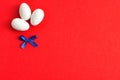Three white easter eggs with a blue bow Royalty Free Stock Photo