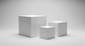 Three white geometric cubes of varying sizes arranged on a light gray background Royalty Free Stock Photo