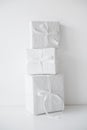 Three white gift boxes packages with ribbons on table Royalty Free Stock Photo