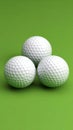 Three white golf balls arranged in a triangle shape against a vibrant green background Royalty Free Stock Photo