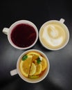 Three white mugs with coffee and tea on a dark background Royalty Free Stock Photo