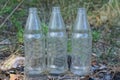 three white old dirty glass bottles stand on the gray ground Royalty Free Stock Photo