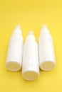 White Plastic Bottles with Spray Caps on a Bright Yellow Background Royalty Free Stock Photo