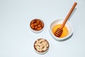 Three white plates with honey, almond and cashew nuts on a white background Royalty Free Stock Photo