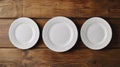 Three White Plates Lined Up on a Rustic Wooden Table Royalty Free Stock Photo