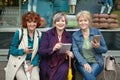 Three white senior women with mobile devices in their hands are smiling. Royalty Free Stock Photo