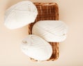 Three white skeins of yarn and a wicker basket. Nice photo for a hobby, vertical orientation. Hobby aesthetics. Royalty Free Stock Photo