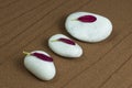 Three White Stones with Petals of Purple Gerber