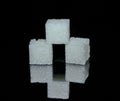 Three white sugar cubes from crystals on black glossy glass Royalty Free Stock Photo