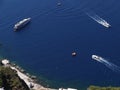 three white vessels travelling in blue aegean sea Santorini island
