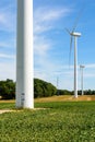 Three wind turbines lined up amid the fields Royalty Free Stock Photo