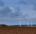 Three wind turbines in a plughed-up field Royalty Free Stock Photo