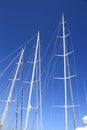 Three white yacht masts on blue sky
