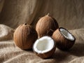 Three whole coconuts and one halved coconut on burlap Royalty Free Stock Photo